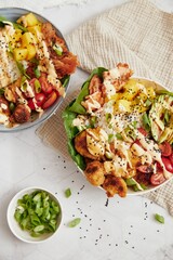 Vertical top shot of delicious vegan food bowls with vegetables on the white table