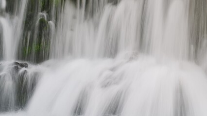 Fototapeta na wymiar Closeup of big foamy waterfall stream splashing down