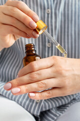 Woman applies moisturizing nourishing oil on her hands. Hand skin care, dryness, dehydration...