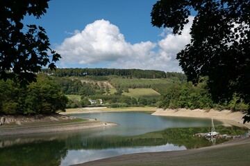 Beach of a Lake Henne, Sauerland, Germany with mountains and blue sky in the background