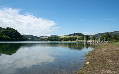 Beach of a Lake Diemel, Sauerland, Germany with mountains and blue sky in the background