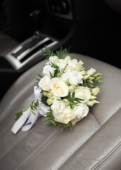 the bride's bouquet lies on the seat of the car