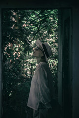 A beautiful girl stands in an abandoned building. Girl in a hat. Concrete walls. A ghostly abandoned building.