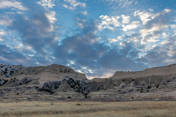 Fototapeta na wymiar Arid cold desert prairie and foothills landscape environment at sunset with blue sky and clouds in Nebraska's Scotts Bluff National Monument.