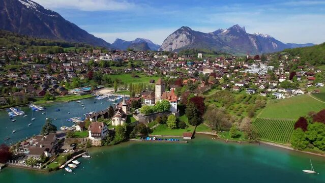 Switzerland travel. scenic lake Thun and the Spiez village aerial drone footage with medieval castle and old town in the alps in Canton Bern 
