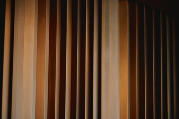 Rhythmic vertical cedar slats create a warm architectural texture accentuated by spotlighting.