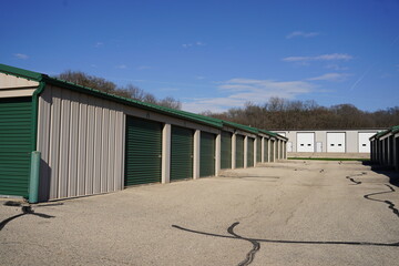 Fototapeta na wymiar Green and white storage units being used to hold rental property and belongings.