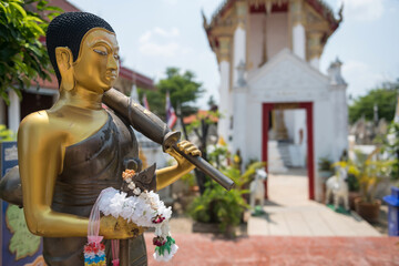 Buddha statue hold umbrella and garland at temple at Koh Kret