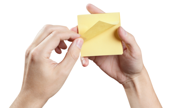 Hands holding stack of yellow stickers, cut out