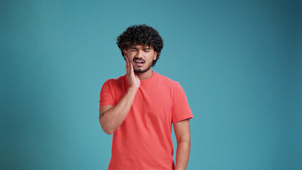 Dental problems. Portrait of unhealthy Indian man pressing sore cheek, suffering acute toothache,...