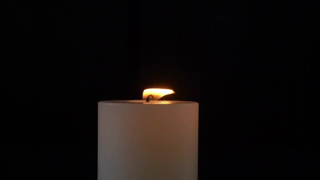 Close-up of a burning candle isolated with black background