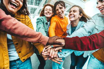 Multiracial group of young people stacking hands outdoors - Happy friends celebrating success on...