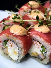 sushi and rolls on the white Japanese plate on black background