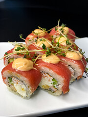 sushi and rolls on the white Japanese plate on black background