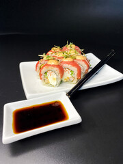 sushi and rolls on the white Japanese plate on black background