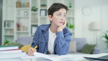Bored schoolboy do task Tired exhausted sad upset fatigued little child boy kid pupil schoolboy schoolchild lying on table desk writing homework boring class lesson drawing in notebook at home