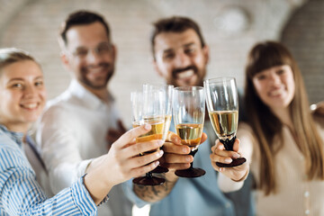 Close up of group of business people having fun and toasting with white wine