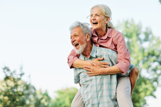 woman man outdoor senior couple happy lifestyle retirement together smiling love fun elderly active vitality nature mature portrait piggyback game