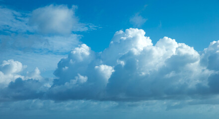 white fluffy clouds with rainbow in the blue sky