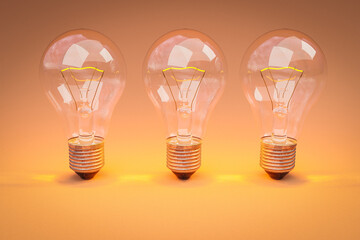 three retro style lightbulbs with glowing filament standing in a row on infinite colorful orange background; creativity design concept; 3D Illustration