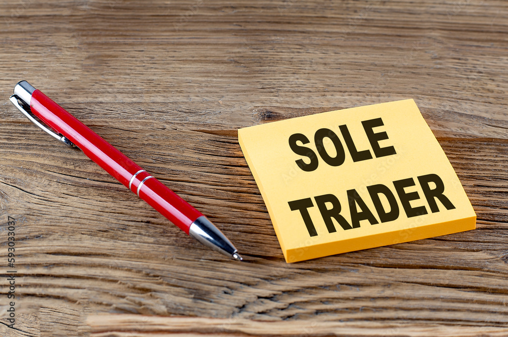 Poster sole trader text on sticky with pen on the wooden background