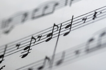 Close up image of a small section of sheet music showing lines and notes with blurred edges