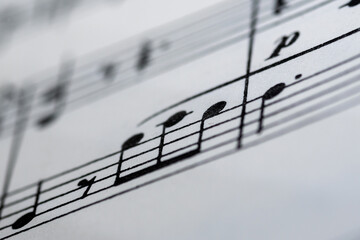 Close up image of a small section of sheet music showing lines and notes with blurred edges