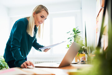 Smiling businesswoman doing accounting while working from home