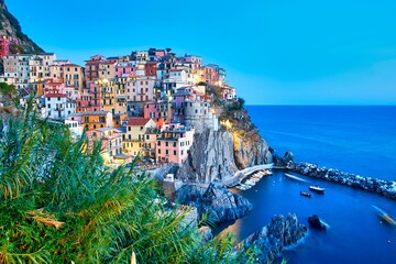 Fototapeta na wymiar Colorful building of the Manarolas town in Cinque Terre Italy surrounded by the calm sea