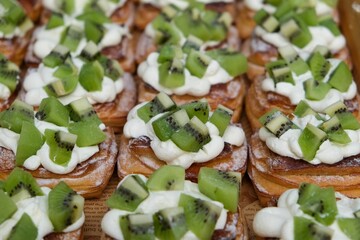Closeup of fresh kiwi tarts with cream