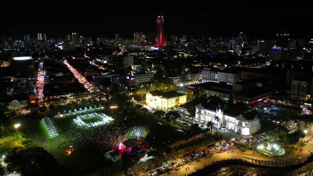Aerial pull back and view crowds gather at Padang Kota Lama in night