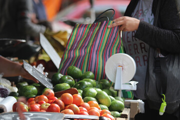 mulher com sacola retornavel em feira de legumes frutas e verduras frescos 