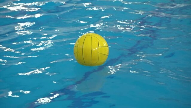 Water polo ball floats on the surface of the water in the pool