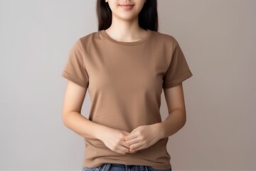 Obraz premium White woman model wearing a plain light brown short sleeved t-shirt, isolated on a blank background. Mock-up, torso only. Generative AI illustration.