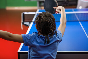 Little girl playing table tennis