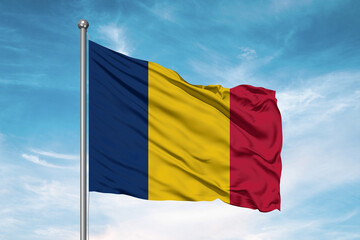 Chad national flag cloth fabric waving on beautiful sky Background.