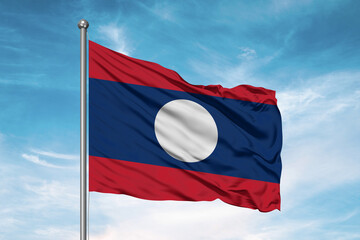 Laos national flag cloth fabric waving on beautiful sky Background.