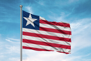 Liberia national flag cloth fabric waving on beautiful sky Background.