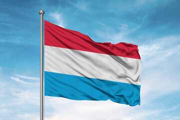 Luxembourg national flag cloth fabric waving on beautiful sky Background.