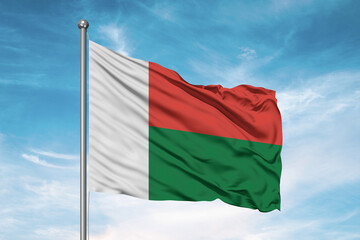 Madagascar national flag cloth fabric waving on beautiful sky Background.