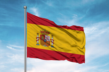 Spain national flag cloth fabric waving on beautiful sky Background.