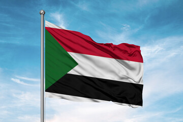 Sudan national flag cloth fabric waving on beautiful sky Background.