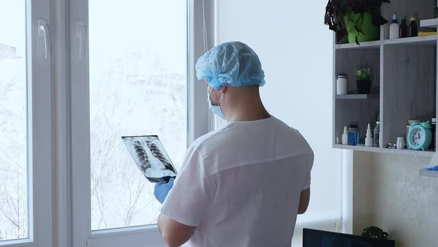 Doctor radiographer analyzes the x-ray of the patient's lungs. Diagnosis of lungs, pneumonia, pulmonary turbeculosis on x-ray.