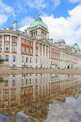 Old Admiralty Building London reflects in a puddle on Horse Guards Parade