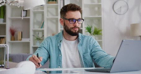 Focused business man entrepreneur typing on laptop sitting at desk in home office making notes working remotely. Freelancer using laptop for work from home preparing report. - Powered by Adobe