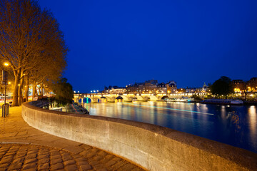 CItyscape of downtown with Pont Neuf Bridge and River Seine at night , Paris.