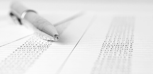 Pen on financial statement and balance sheeet on desk of auditor. Concept of accounting and audit...