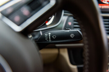 Automatic control of wipers. Helm of car, steering wheel close up. Modern interior in an expensive complete set. Car interior from the inside. Closeup details.