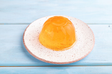 Apricot orange jelly on blue. side view.
