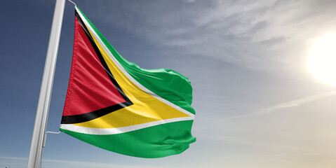 Guyana national flag cloth fabric waving on beautiful sky grey Background.